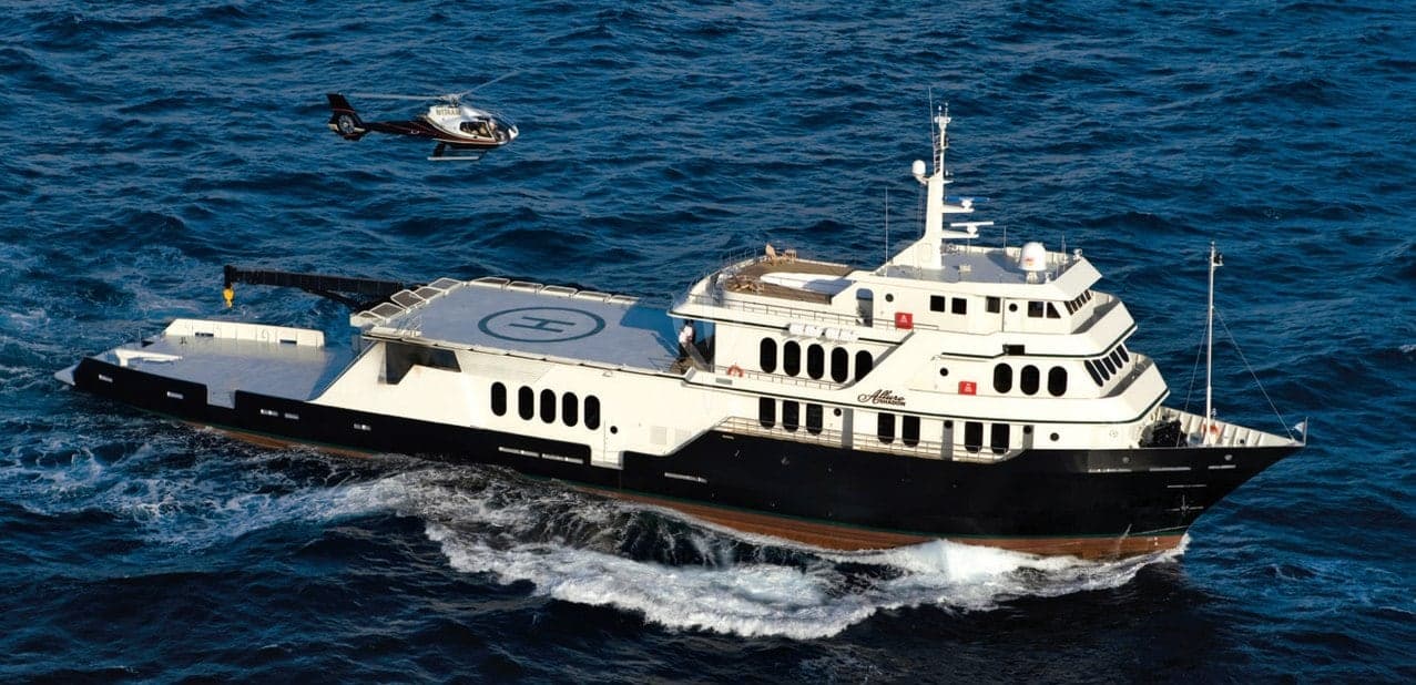 M/Y Global under way at sea with her helicopter overhead